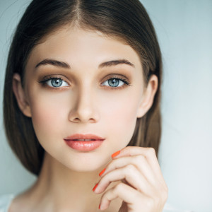 Indoor shot of young beautiful woman on light background