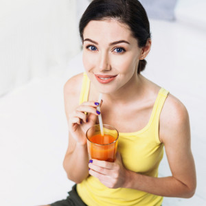 Beautiful woman holding glass of orange juice
