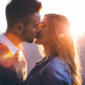Young couple kissing in park.