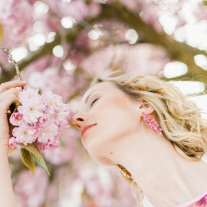 Woman outdoors in park by pink blossom tree