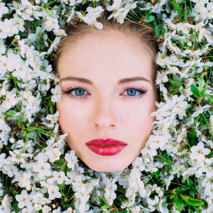 Portrait of beautiful young woman  among the cherry flowers