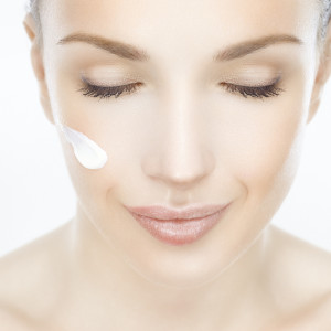 Close-up of a beautiful woman with cream on her face