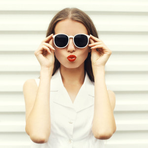 Fashion portrait of pretty young woman in white sunglasses