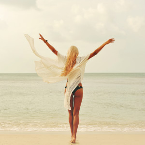 Woman enjoying nature at the beach. Arms wide open, freedom