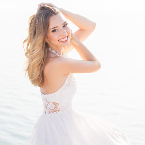 Beautiful smiling young bride girl over the sea view