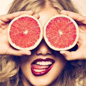 funny-portrait-girl-holding-red-grapefruit-infront-of-her-face-picture-id161961914