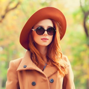 redhead-girl-in-sunglasses-and-hat-in-the-autumn-park-picture-id517997267