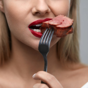 肉を食べる女性