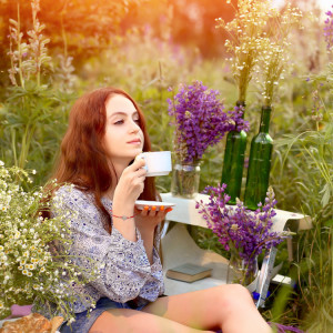 Young,Girl,Holds,White,Cup,With,Summer,Flowers,And,Herbs